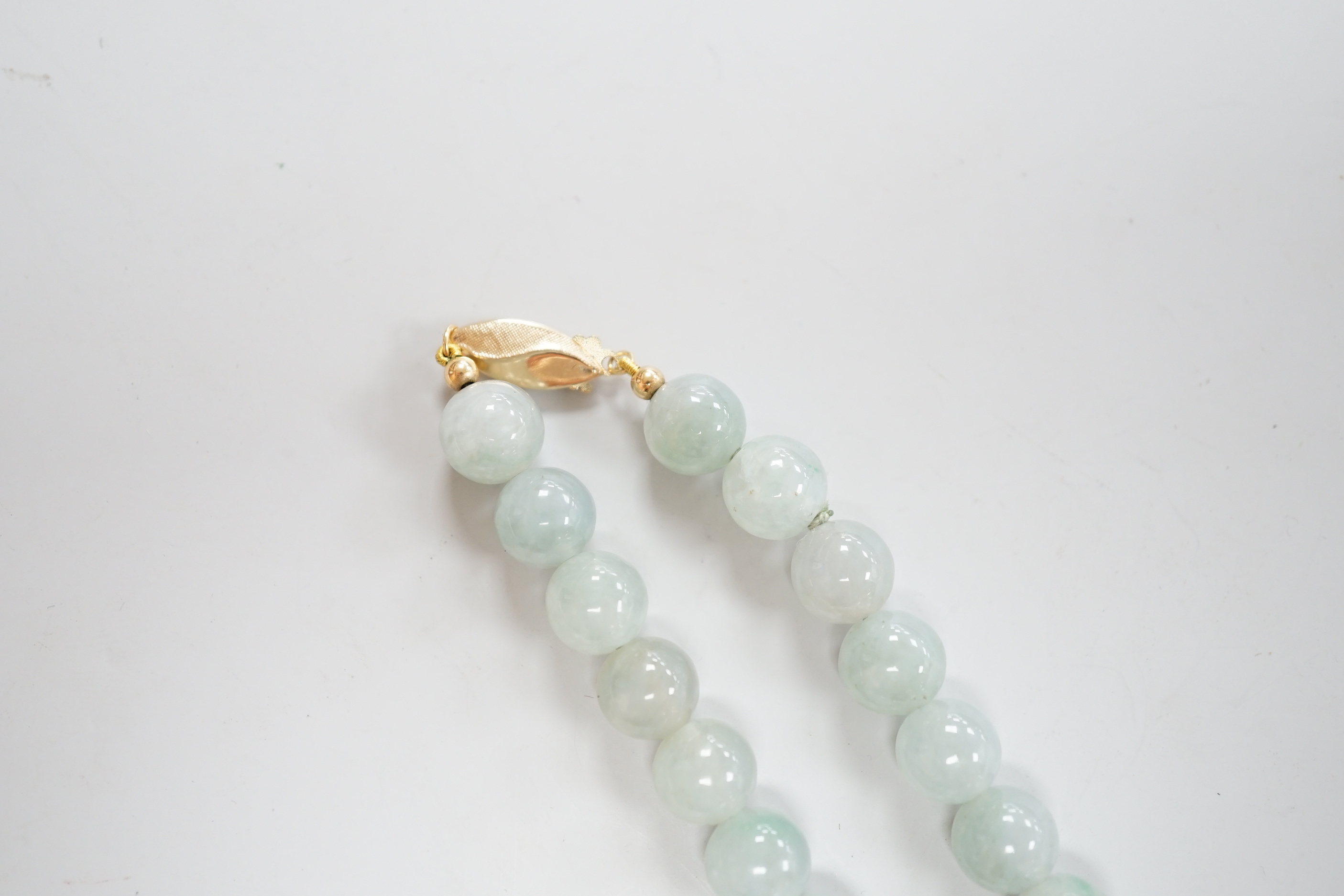 A single strand jadeite bead necklace, with 18k clasp, 43cm, gross weight 58.7 grams, with accompanying Gem & Pearl Laboratory report dated 18/03/2019, stating the jade to have no evidence of treatment.